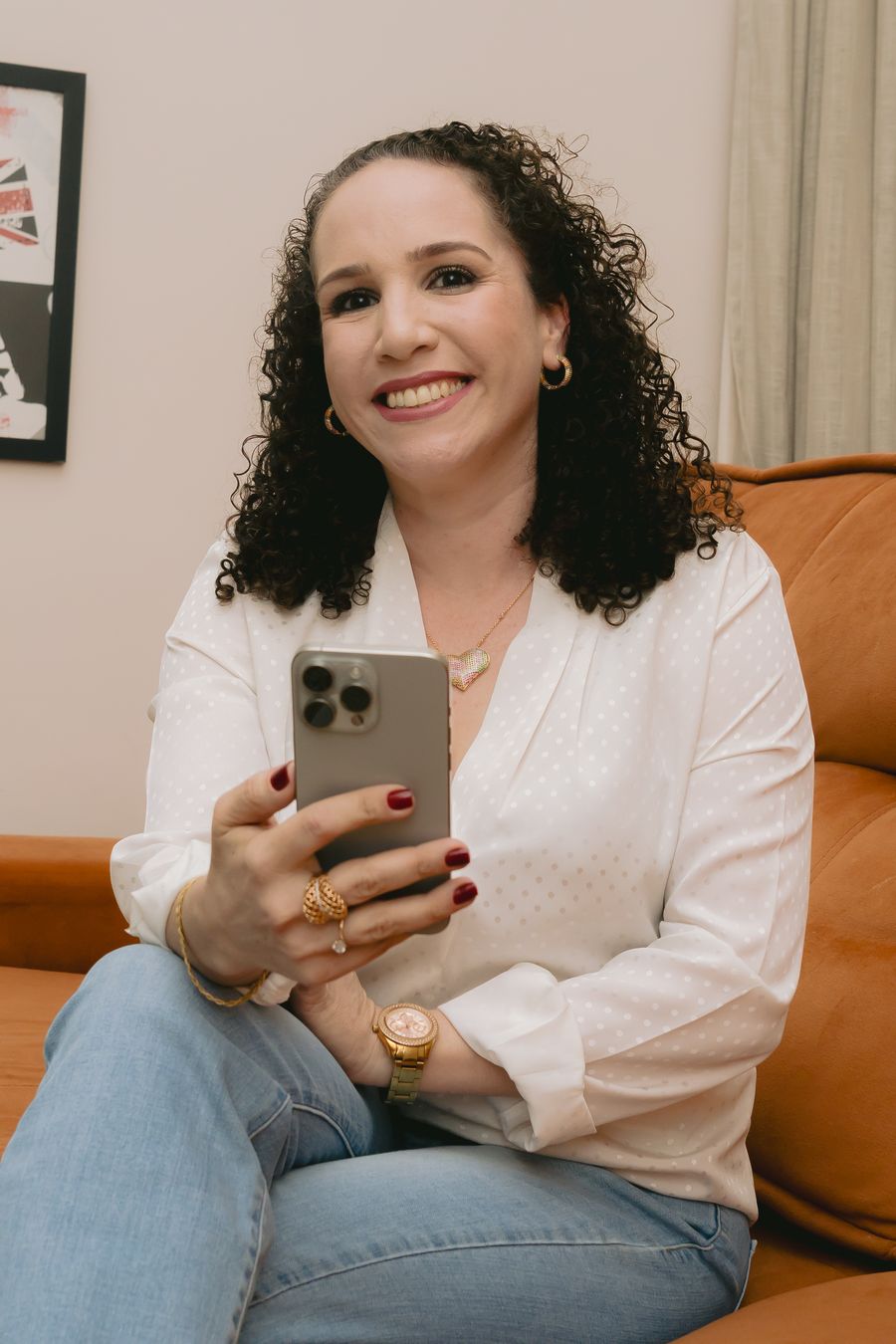 Luiza Ribeiro sorrindo com o celular na mão