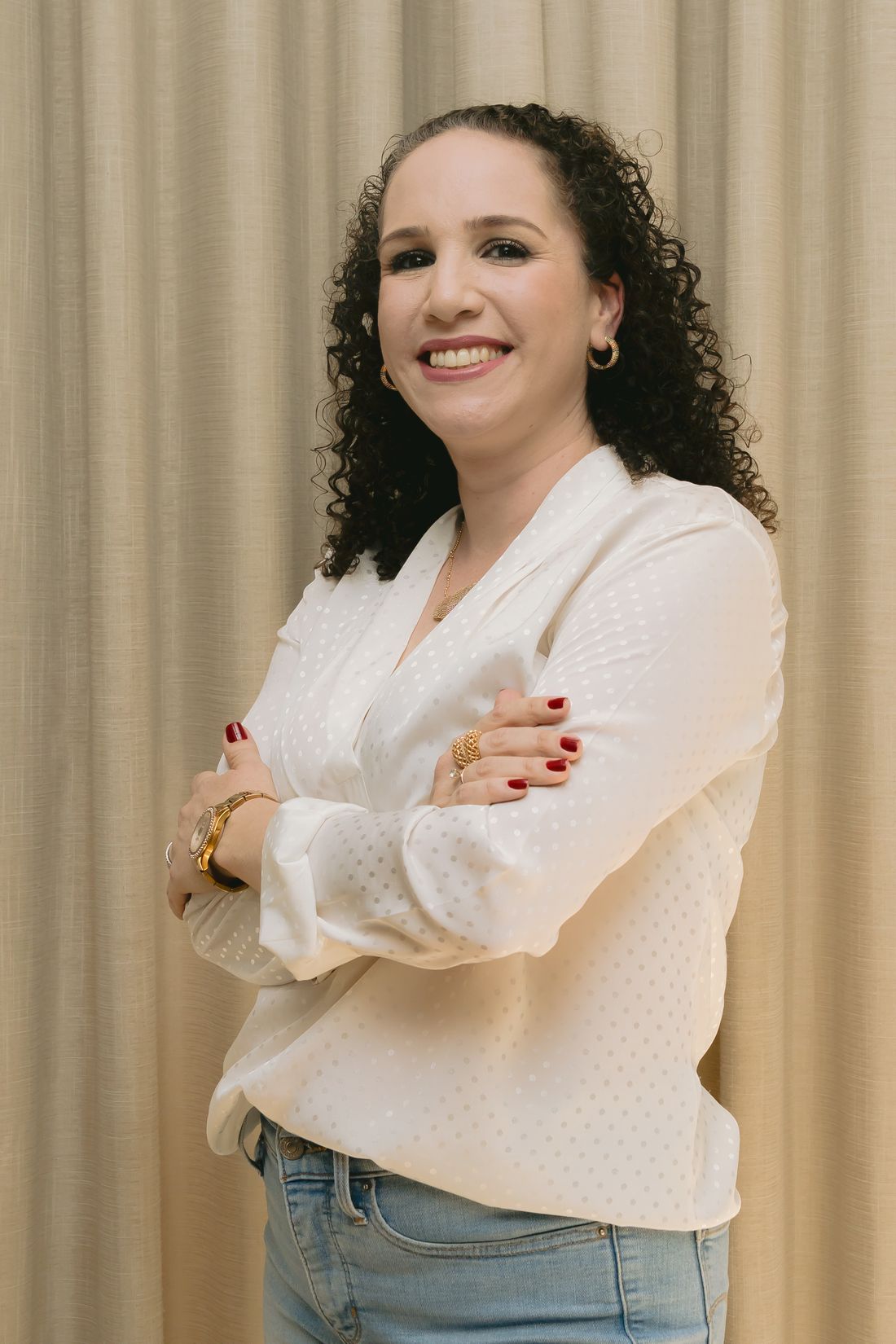 Luiza Ribeiro, consultora de consórcio, sorrindo de braços cruzados
